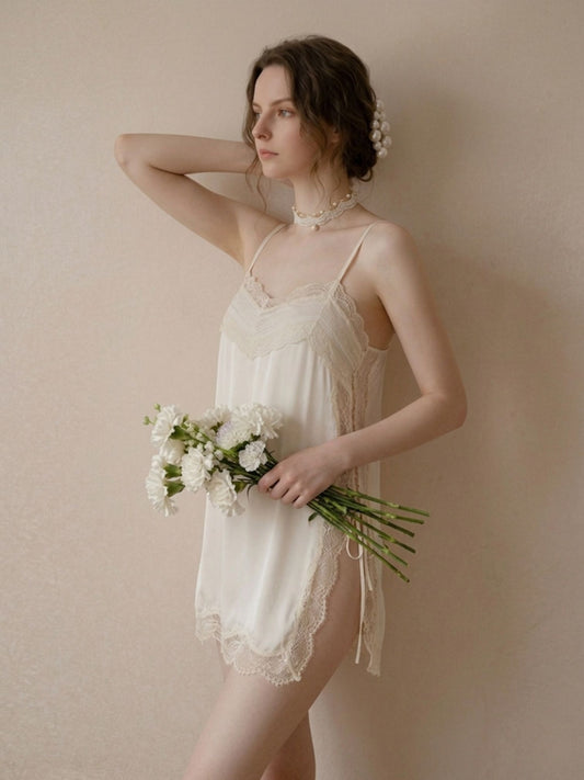 Woman in a white lace nightgown holding flowers against a beige background