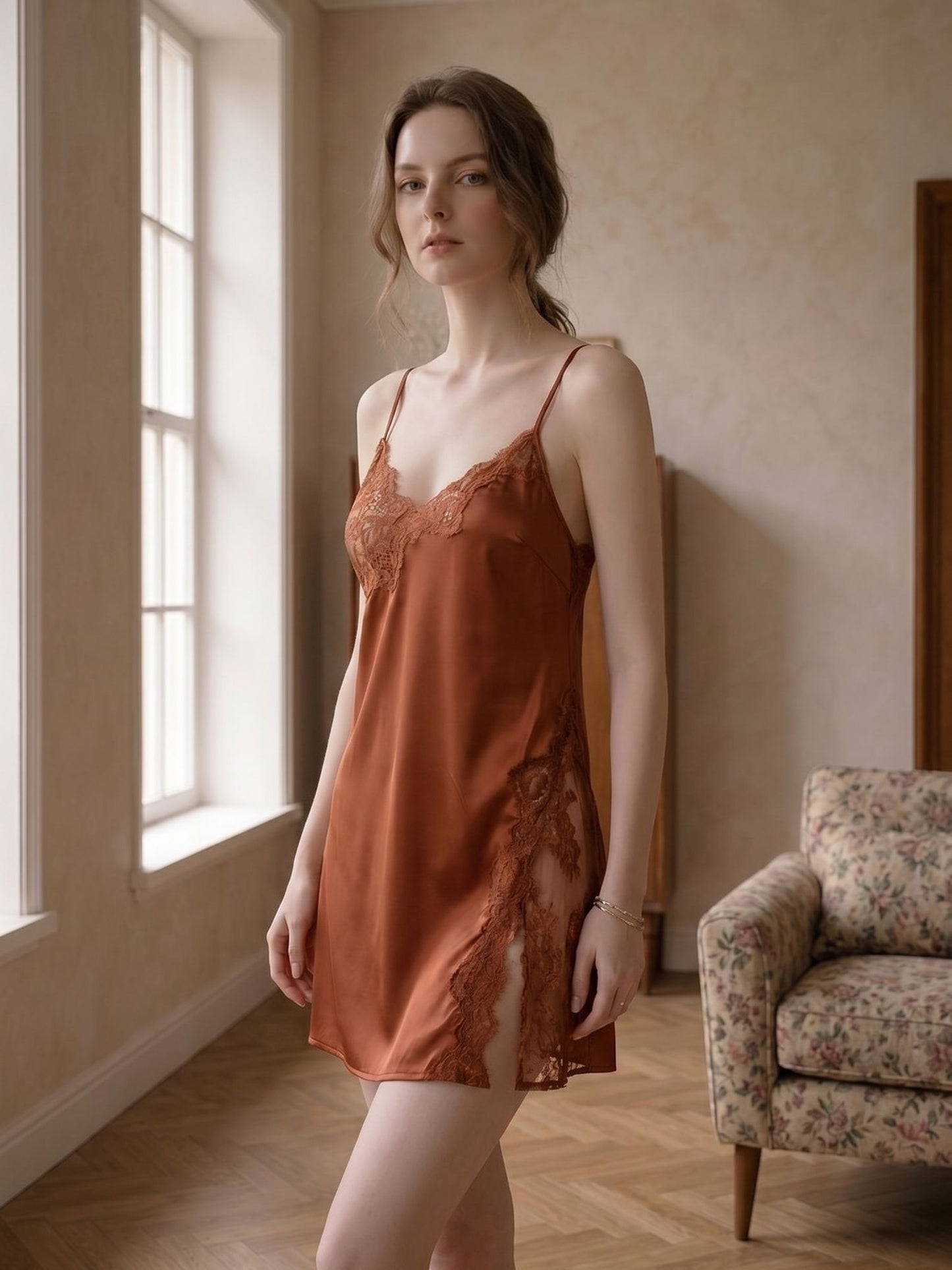 Woman wearing a rust-colored slip dress standing in a softly lit room.