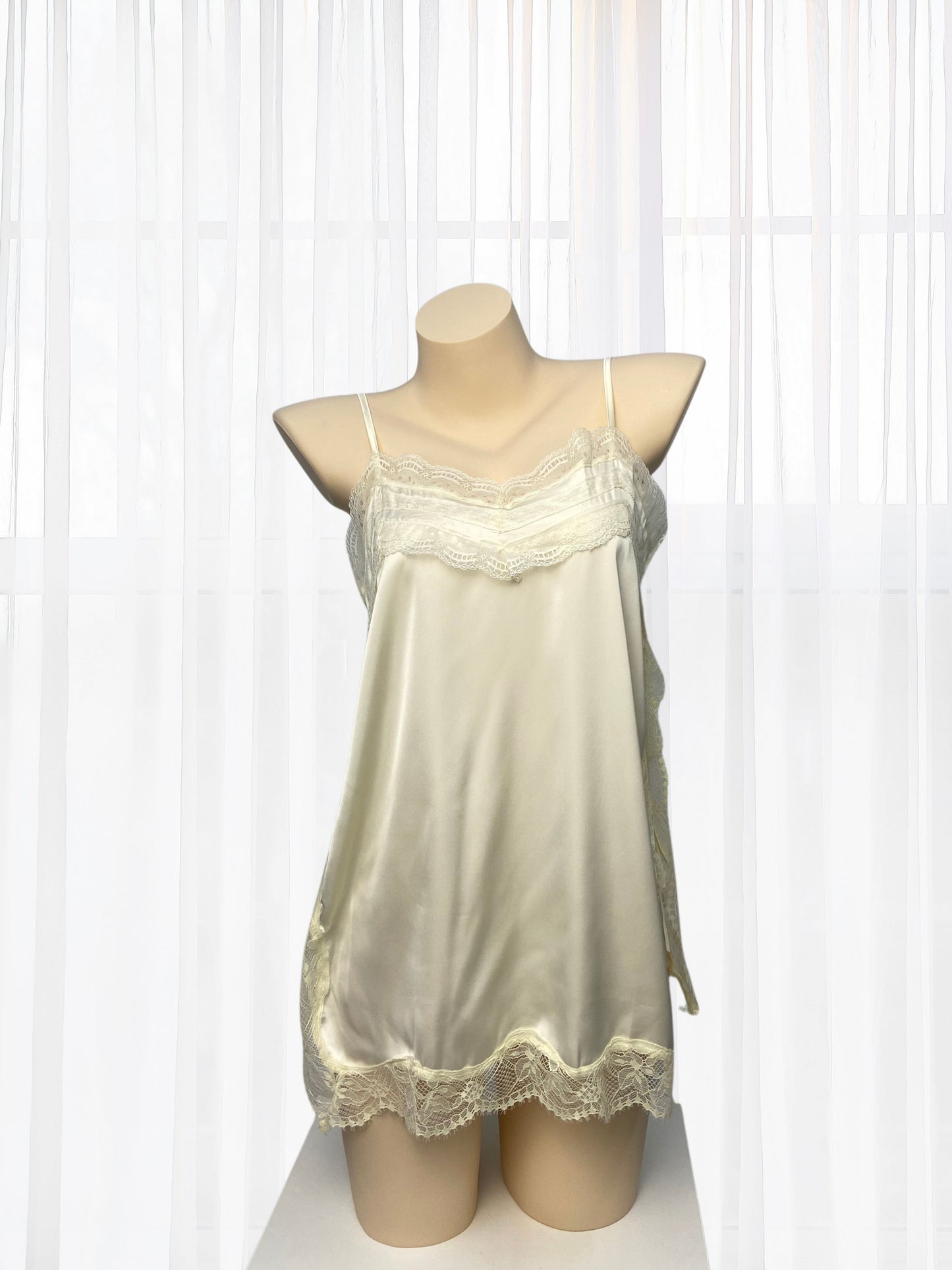 Cream-colored nightgown with lace details on a mannequin against a white background