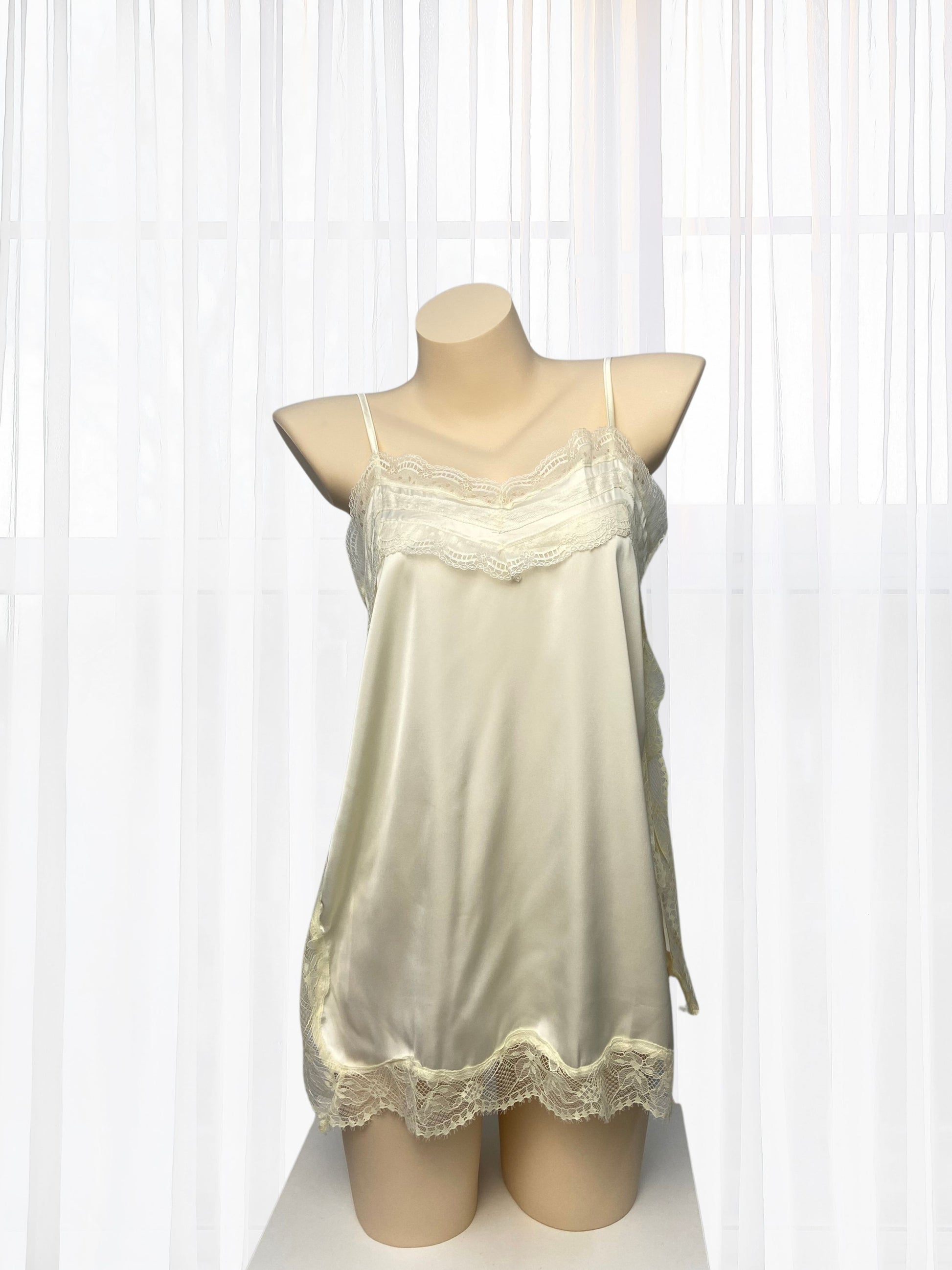 Cream-colored nightgown with lace details on a mannequin against a white background