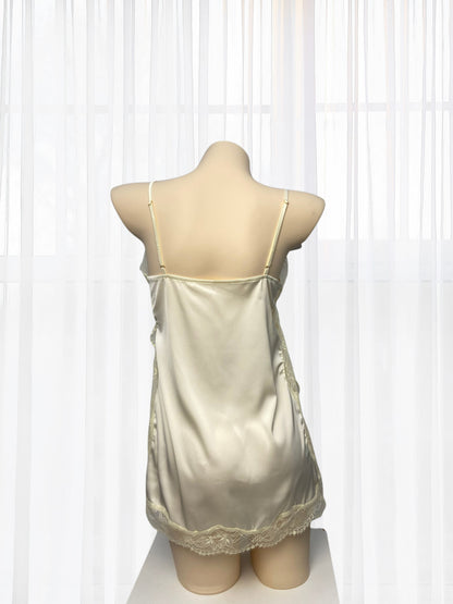 Beige satin nightgown on a mannequin against a white curtain background