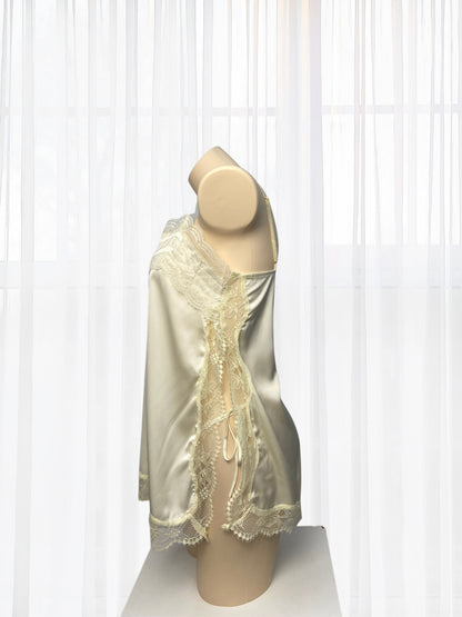 Mannequin wearing a cream-colored lace dress with gold accents against a white background