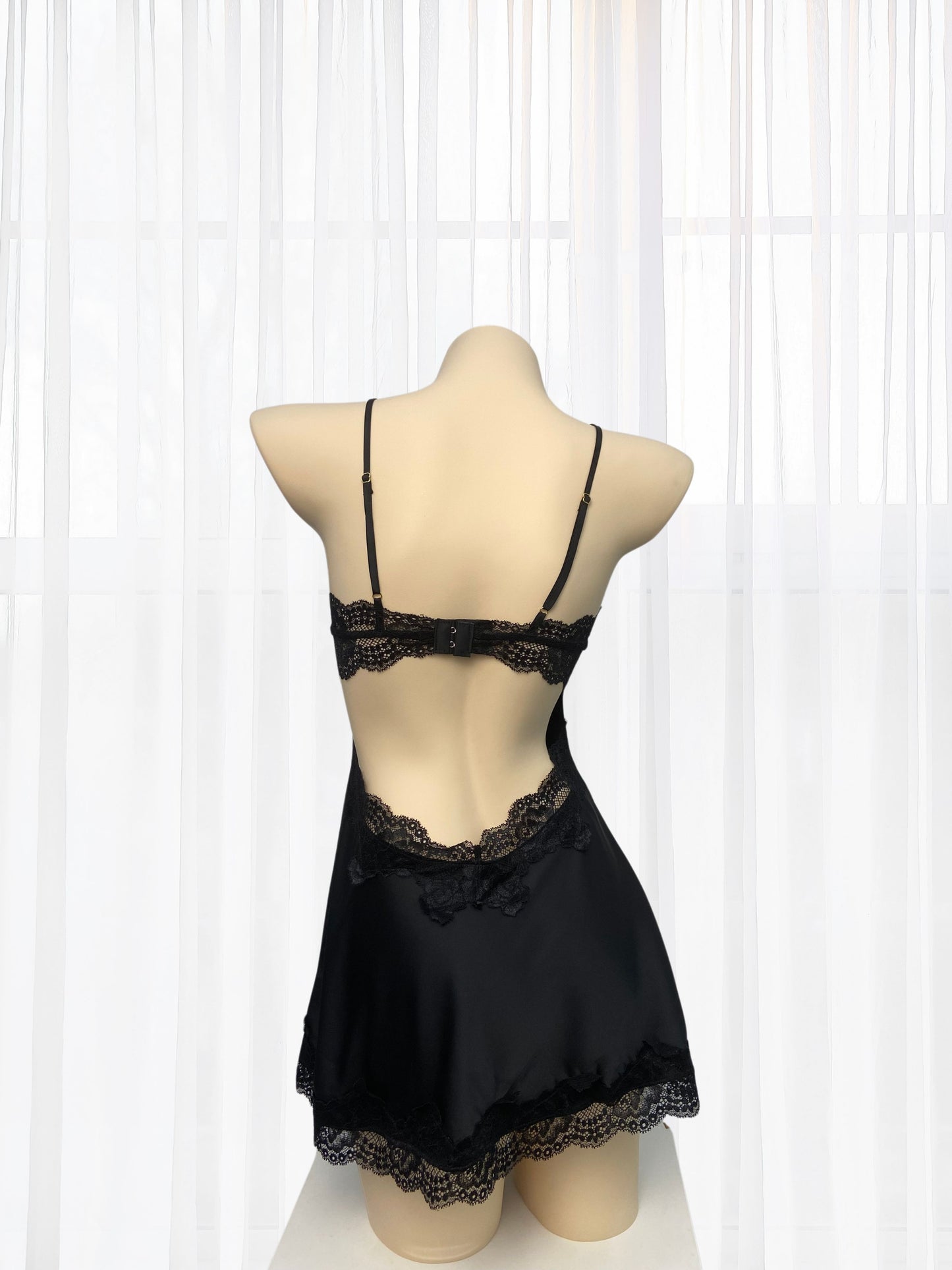 Black lace lingerie set on a mannequin against a white background